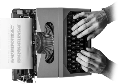 Hands typing on a vintage typewriter